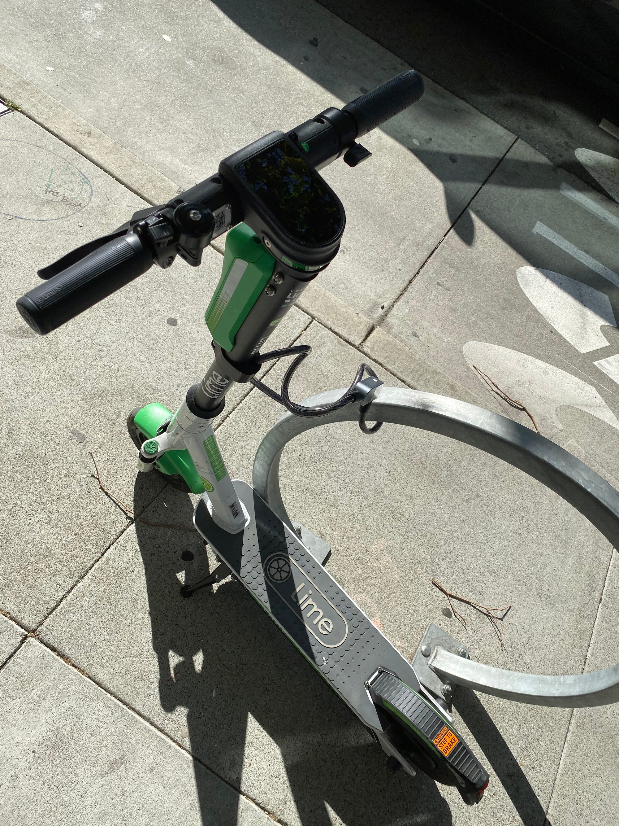 サンフランシスコの歩道の駐輪ラックに停められた Lime の電動キックスクーター