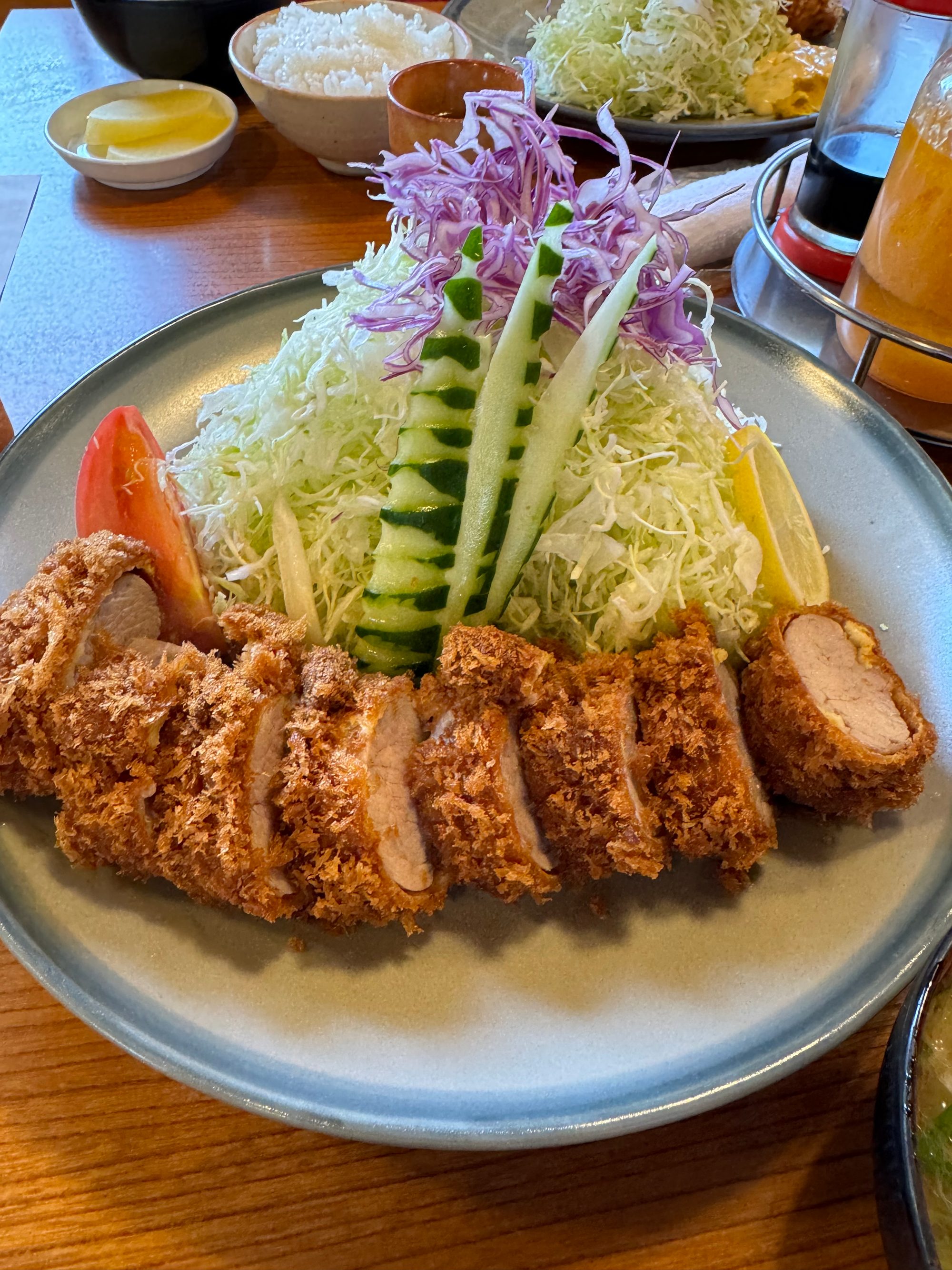 とんかつ大関のとんかつ。厚切りのカツと千切りキャベツ、飾り切りのきゅうりや紫キャベツ