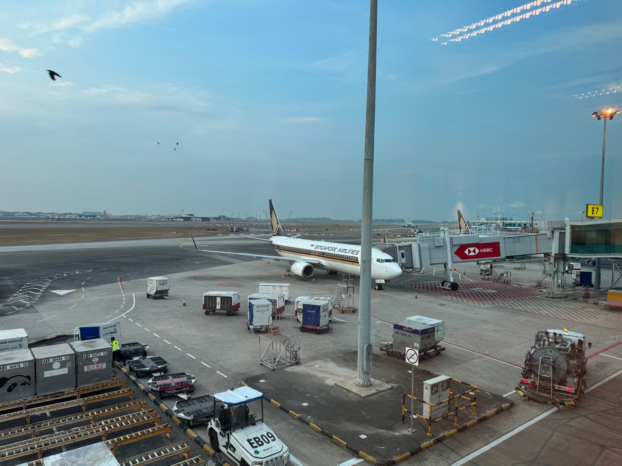 シンガポール・チャンギ空港。ゲート E7 に停まるシンガポール航空機と HSBC 広告のボーディングブリッジ