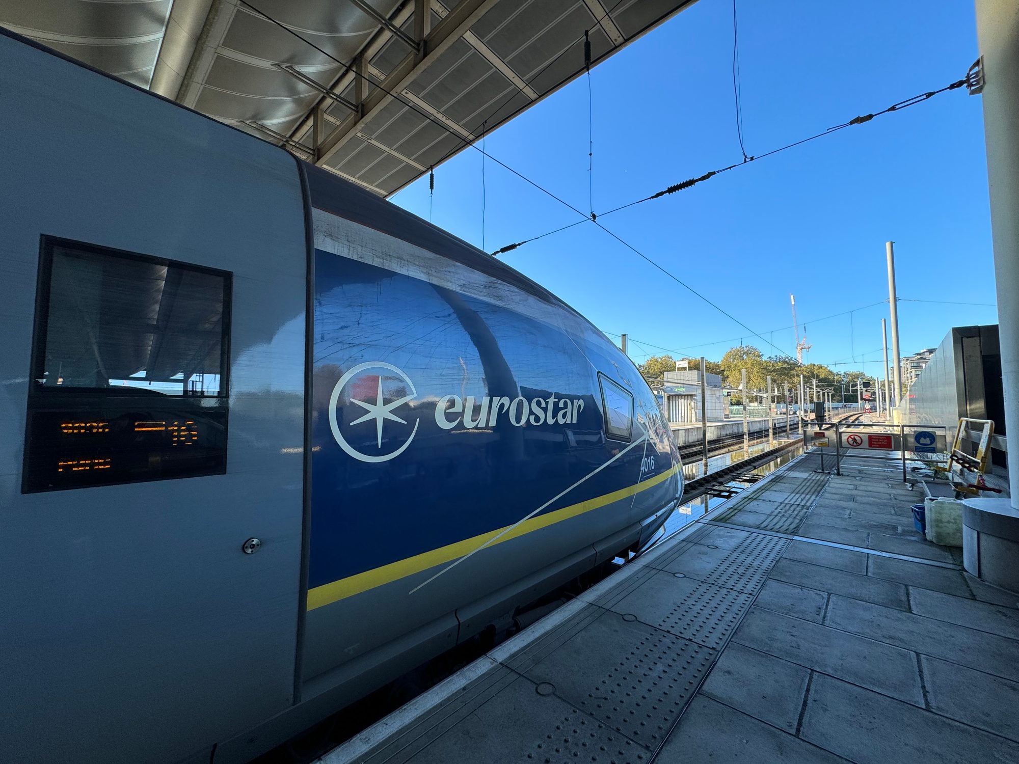 駅のホームに停車する Eurostar の青い先頭車両。快晴の空