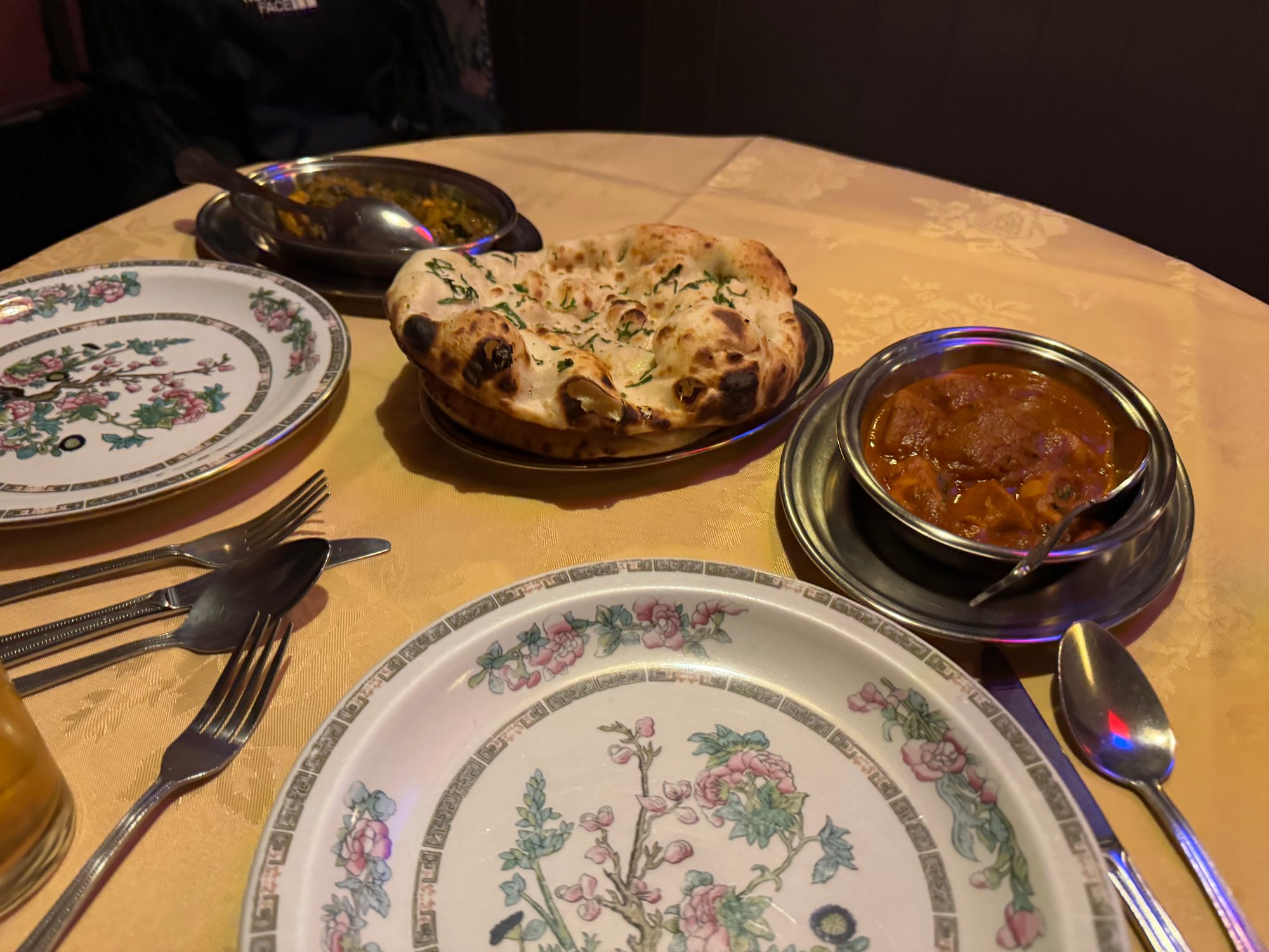 オックスフォードのインド料理店。ナンとカレー、サイドの野菜料理が花柄の皿とともに並ぶ