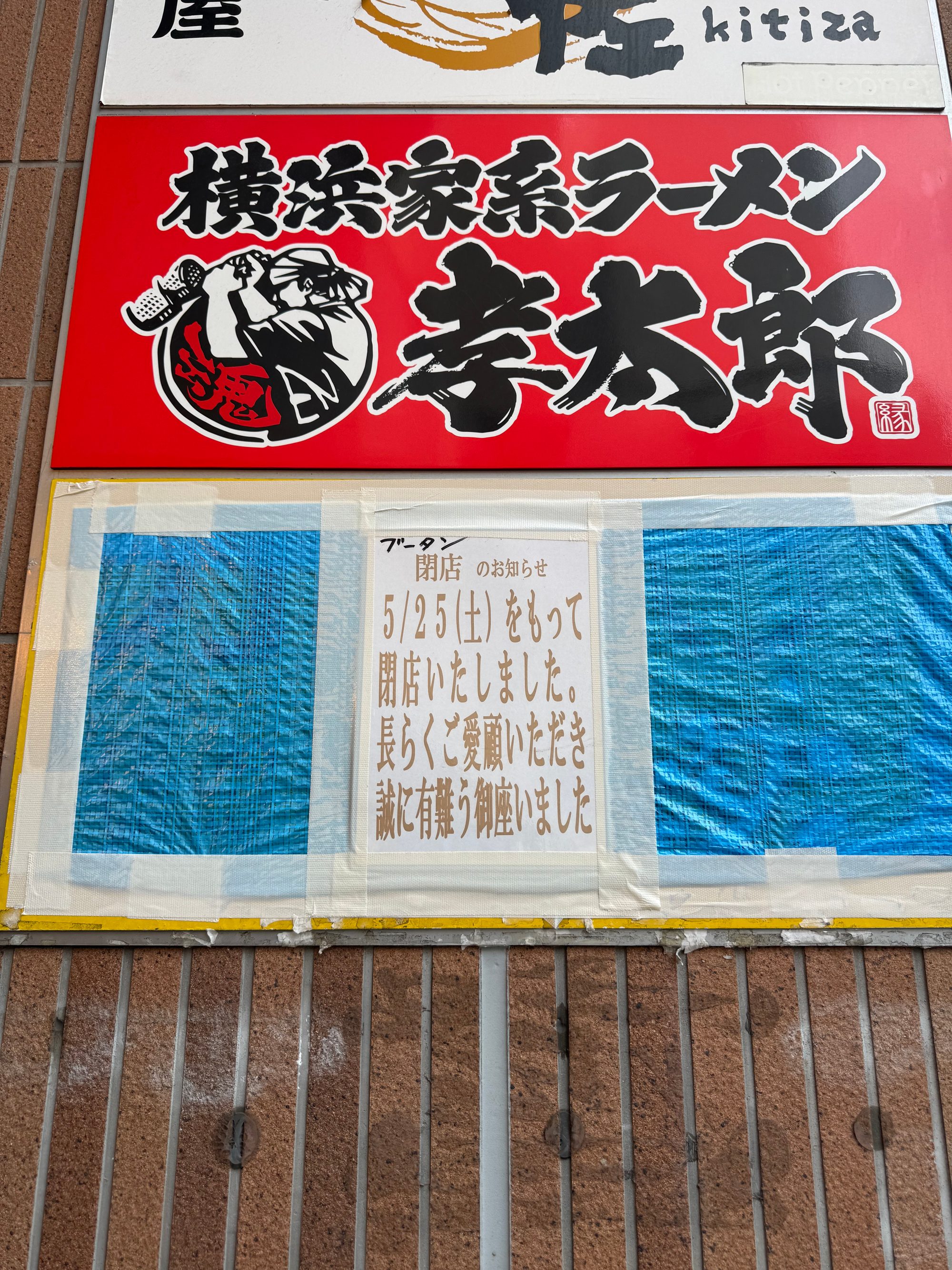 閉店の貼り紙（5/25をもって閉店）が貼られた茅ヶ崎駅前の店舗。横浜家系ラーメンの看板とシャッター